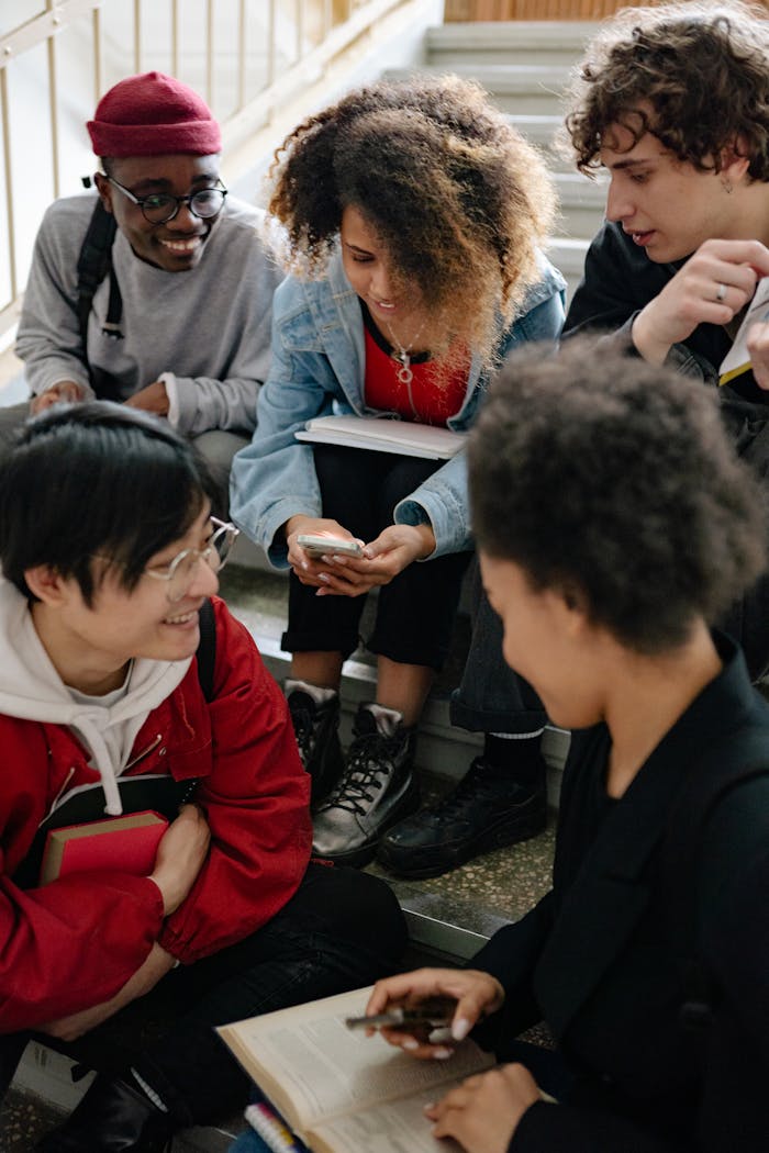 A diverse group of university students studying on stairs, promoting teamwork and education.